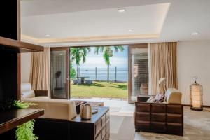 a living room with a view of the ocean at Bamboo Rimbun-Tranquil Seaside Villa, Port Dickson in Port Dickson