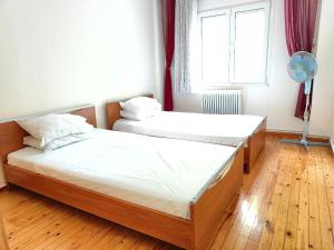 two beds in a room with a window at 3BR Spacious City Center in Thessaloniki