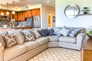 Una sala de estar con un sofá con almohadas. en Pili Mai 8I, en Koloa