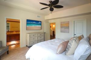 Un dormitorio con una cama blanca y un ventilador de techo. en Pili Mai 8I, en Koloa 36 fotos más