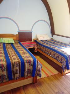 two beds sitting next to each other in a room at Hostal Qhana Pacha in Isla de la Luna