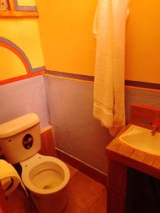 a bathroom with a white toilet and a sink at Hostal Qhana Pacha in Isla de la Luna