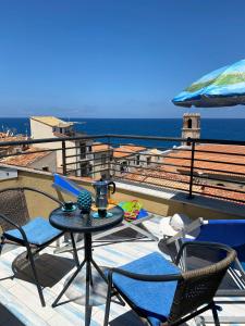 een terras met een tafel en stoelen op een dak bij Dolce Estate Cefalù in Cefalù