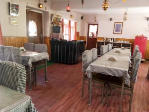 ein Restaurant mit Tischen und Stühlen in einem Raum in der Unterkunft Hotel Gyespa in Kyelang