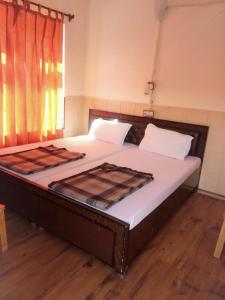 a large bed in a room with a wooden floor at Hotel Gyespa in Kyelang
