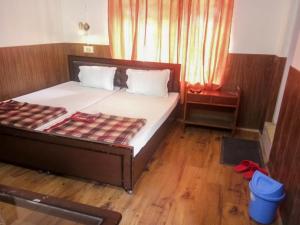 a bedroom with a bed with a wooden floor at Hotel Gyespa in Kyelang
