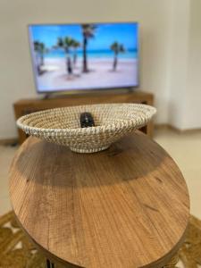 a bowl on top of a wooden table with a television at Apartamentos Cumbremar en Benicàssim in Benicàssim