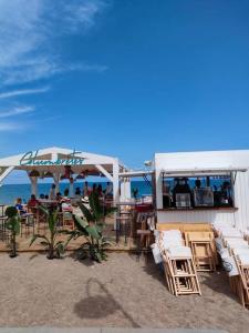 un restaurante en la playa con mesas y sillas en Apartamentos Cumbremar en Benicàssim en Benicàssim