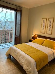 a bedroom with a large bed and a large window at Hotel Casa Aure in Santiago