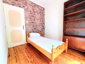 a bedroom with a bed and a brick wall at 3BR Spacious City Center in Thessaloniki