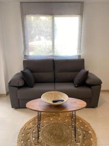 sala de estar con sofá y mesa en Apartamentos Cumbremar en Benicàssim en Benicàssim