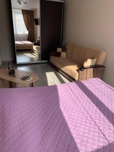 - un salon avec un lit violet et un canapé dans l'établissement Одесса ЖК 7 Небо/Аквапарк/7км, à Odessa