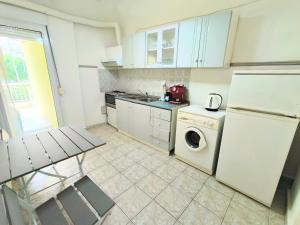 a kitchen with a white refrigerator and a washing machine at 3BR Spacious City Center in Thessaloniki