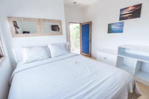 a white bedroom with a white bed and a window at The Island Bali in Seminyak