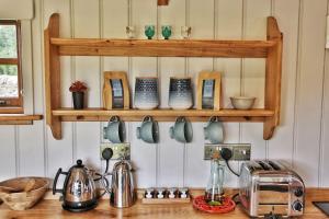 una encimera de cocina con ollas y tazas en un estante en FLORA Luxury Retreat, Private Garden, Views & Hot Tub, en Durham