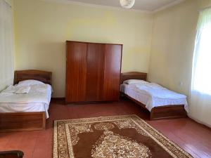 1 dormitorio con 2 camas, armario y alfombra en Tamara B&B, en Tumanyan