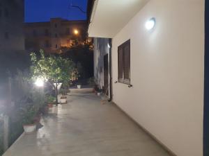 un couloir vide d'un bâtiment blanc la nuit dans l'établissement Casa Consiglio, à Realmonte