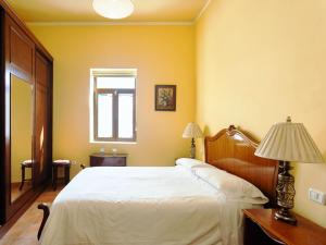 a bedroom with a white bed and a window at Live Buenavista del norte con terazza in Buenavista del Norte