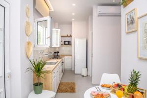 a kitchen with white cabinets and a table with fruit on it at Olivia’s House in Kavos
