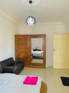 1 dormitorio con cama, sofá y espejo en Appartement xandra 2, en Dakar