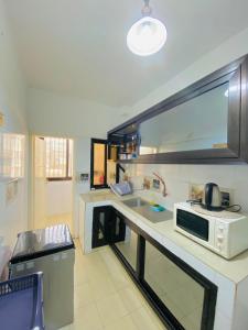 cocina con fregadero y microondas en Appartement xandra 2, en Dakar