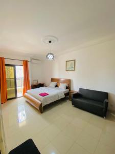 1 dormitorio con 1 cama y 1 sofá en Appartement xandra 2, en Dakar