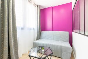 een kleine kamer met een bed en een roze muur bij Nets Inn - Botzaris in Parijs