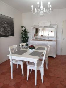 een eetkamer met een witte tafel en stoelen bij Vila Mar Apartment in Vila do Conde