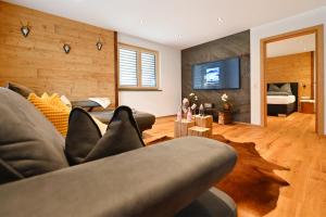 uma sala de estar com um sofá e uma televisão em Apartment Bergliebe em Sankt Gallenkirch
