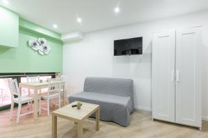 een woonkamer met een bank en een tafel bij Nets Inn - Botzaris in Parijs