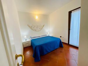 a bedroom with a blue bed and a window at Piazza ginestre porto rotondo in Porto Rotondo