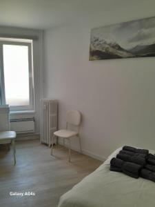 a bedroom with a bed and a chair and a window at 1 bedroom studio sleeps 4 in Brussels