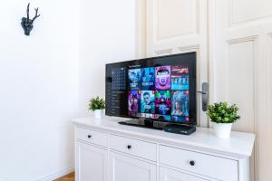 een flatscreen-tv op de top van een witte dressoir bij Budafoki Residence in Boedapest