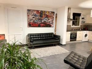 sala de estar con sofá de cuero negro en la cocina en Art_Booking . . . by Benoit_B, en Duingt