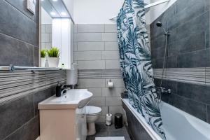 Un baño con lavabo, inodoro y bañera. en Budafoki Residence, en Budapest