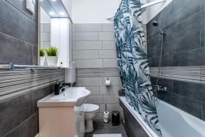 a bathroom with a sink and a toilet and a tub at Budafoki Residence in Budapest