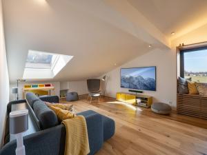 ein Wohnzimmer mit einem blauen Sofa und einem TV in der Unterkunft Ferienwohnung BT Sieben in Oberaudorf