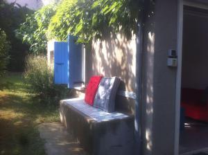 um banco com um saco vermelho sentado em cima dele em Ardèche, studio indépendant dans jardin em Chomérac