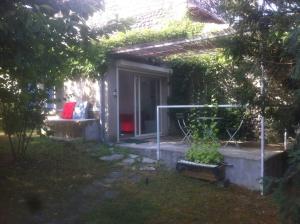 una casa con porche y un sofá en un patio en Ardèche, studio indépendant dans jardin, en Chomérac