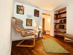 a living room with a chair and a book shelf at Appartement messier mezzanine in Senones