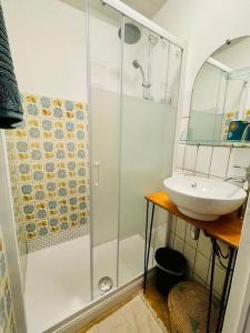 a white bathroom with a shower and a sink at Appartement messier mezzanine in Senones
