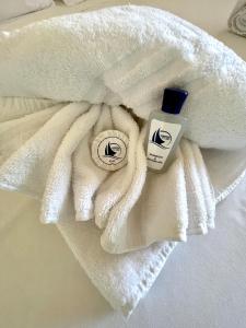 Una toalla blanca con una botella de loción. en SAN TEODORO PUNTA EST MONOLOCALE VISTA MARE, en Capo Coda Cavallo