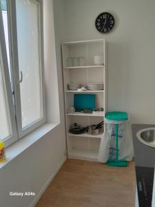 a kitchen with a sink and a clock on a shelf at 1 bedroom studio sleeps 4 in Brussels
