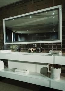 a mirror above a sink in a bathroom at Waves Aqua Resort in Kenitra