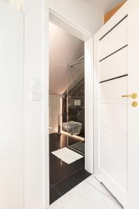 ザトルにあるBianco Apartamenty Laskowa - Zatorのバスルーム(トイレ付)へ続くガラスドアが備わります。