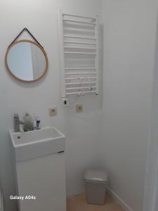 a white bathroom with a sink and a mirror at 1 bedroom studio sleeps 4 in Brussels