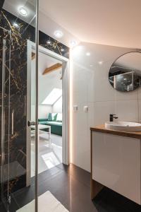 ザトルにあるBianco Apartamenty Laskowa - Zatorのバスルーム(洗面台、ガラス張りのシャワー付)