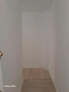 um quarto com paredes brancas e piso em madeira em 1 bedroom studio sleeps 4 em Bruxelas