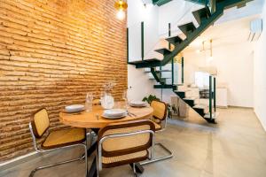 a dining room with a table and chairs and a brick wall at Casa Bonita in Almería