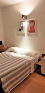 a bedroom with a bed and some pictures on the wall at Casale del Mare in Castiglioncello